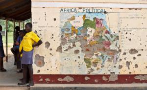FILE - In this Nov. 15, 2016 file photo, students line up outside a classroom with a map of Africa on its wall, in Yei, in southern South Sudan. The Obama administration is set to ease sanctions against Sudan and broaden now limited talks with the long estranged African government, a U.S.-designated terrorism sponsor whose leader has been indicted on war crimes charges, The Associated Press learned Thursday, Jan. 12, 2017. (AP Photo/Justin Lynch, File)