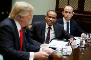 Stephen Miller, senior adviser to President Donald Trump, right, and Larry McKenney of Capitol Radiology listen as Trump speaks during a meeting with business leaders in the Roosevelt Room of the White House in Washington, Monday, Jan. 30, 2017. (AP Photo/Evan Vucci)