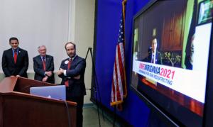 Del. Sam Rasoul, D-Roanoke, left, Del. Kenneth R. Plum, D-fairfax, center, and Brian Cannon, Executive Director of ONEVIRGINIA2021, Virginians for Fair Redestricting, watch a video featuring "Del. Jerry Mander", a spoof on Virginia lawmakers drawing their own legislative boundaries, during a press conference in the General Assembly Building in Richmond, Va., Monday, Jan. 23, 2017. (Bob Brown/Richmond Times-Dispatch via AP)