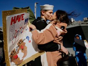 In costume and carrying a sign reading, "Have u seen my significant otter?" Melanie Till welcomes her husband, P.O. 3rd Class David Till, home after the USS Dwight D. Eisenhower returned to Naval Station Norfolk, in Norfolk, Va., on Friday, Dec, 30, 2016, from a seven-month deployment to the Middle East and the Mediterranean Sea. (Stephen M. Katz/The Virginian-Pilot via AP)