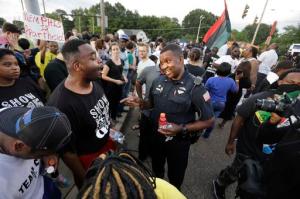 FILE - In this Aug. 15, 2016 file photo, Memphis police department Lieutenant A. Gardner, center right, talks with a protester, Antonio Blair, center left, during a protest at  Graceland's Elvis Candelight Vigil in Memphis, Tenn. Five people have filed a federal civil rights lawsuit against the city of Memphis and Elvis Presley's Graceland, saying they were discriminated against at a protest by a coalition associated with the Black Lives Matter movement during the annual vigil commemorating the singer's death. Graceland owner, Elvis Presley Enterprises, and the city are named in the complaint filed Wednesday, Jan. 18, 2017 in federal court. (Nikki Boertman/The Commercial Appeal via AP)
