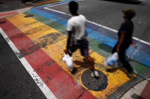 FILE - In this June 17, 2016, file photo, people walk across a rainbow crosswalk painted in support of the LGBT community in the Gayborhood, a gay-friendly section of Philadelphia. The Philadelphia Commission on Human Relations recommended Monday, Jan. 23, 2017, that bars and nonprofit organizations in Philadelphia's gay neighborhood undergo training for racial bias and hire more diverse staff, after a new city report found women, minorities and transgender people have felt unwelcome and unsafe in the Gayborhood for decades. (AP Photo/Matt Rourke, File)