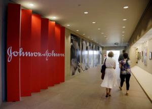 FILE - In this July 30, 2013, file photo, people walk along a corridor at the headquarters of Johnson & Johnson in New Brunswick, N.J. Amid the storm over soaring medicine prices, health care giant Johnson & Johnson says that beginning in February 2017 the company will disclose average increases in the list price and what middlemen actually pay for its prescription drugs. That will help J&J’s image more than patients initially, experts say, but it could push other drugmakers to restrain future price increases and be more transparent. (AP Photo/Mel Evans, File)