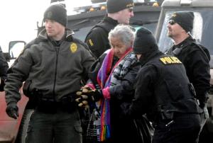 An elderly woman is escorted to a transport van after being arrested by law enforcement at the Oceti Sakowin camp as part of the final sweep of the Dakota Access pipeline protesters in Morton County, Thursday, Feb. 23, 2017, near Cannon Ball, N.D. (Mike McCleary/The Bismarck Tribune via AP, Pool)