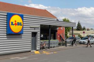 FILE - In this Thursday, June 16, 2011, file photo, people walk into a Lidl supermarket in Chambourcy, 30 kms (29 mls) west of Paris. Lidl, the German no-frills supermarket chain, is opening its first wave of stores in the U.S. summer 2017 ahead of schedule, announced Wednesday, Feb. 15, 2017. (AP Photo/Michel Euler, File)
