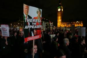 Demonstrators hold placards as they listen to speeches Monday Feb. 20, 2017, in London, during a rally in Parliament Square opposing U.S. President Donald Trump as MPs debate his planned state visit to the United Kingdom. (AP Photo/Tim Ireland)