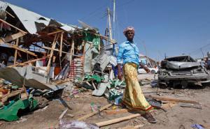 A man walks past the wreckage of shops destroyed by a blast in a market in the capital Mogadishu, Somalia, Sunday, Feb. 19, 2017. A Somali police officer says a blast at a busy market in the western part of Somalia's capital tore through shops and food stands and killed more than a dozen people and wounded many others. (AP Photo/Farah Abdi Warsameh)