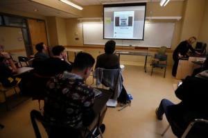In this Friday, Jan. 20, 2017, photo, students in a journalism course at Kean University in Union, N.J., watch a presentation on fake news. Teachers from elementary school through college have been ramping up media literacy training to recognize bogus reports and understand their potential to weaken civic culture. (AP Photo/Julio Cortez)
