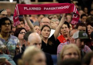 FILE- In this Feb. 9, 2017, file photo, a person supporting Planned Parenthood looks on during Rep. Jason Chaffetz's town hall meeting at Brighton High School in Cottonwood Heights, Utah. Sixteen states ban abortions starting at about 20 weeks, according to Guttmacher Institute, a research organization that supports abortion rights. Utah allows such procedures, but last year passed the first law in the nation to require anesthesia or painkillers for fetuses after 20 weeks. Planned Parenthood Association of Utah CEO Karrie Galloway says her doctors are trying to comply with the law, but there is no clear guidance in the law or from state officials on how to do so. (AP Photo/Rick Bowmer, File)