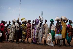 In this photo taken Wednesday, Oct. 19, 2016 and released by UNICEF, women who fled fighting in nearby Leer in recent months, queue for food aid at a food distribution made by the World Food Programme in Bentiu, South Sudan. Famine has been declared Monday, Feb. 20, 2017 in two counties of South Sudan, according to an announcement by the South Sudan government and three U.N. agencies, which says the calamity is the result of prolonged civil war and an entrenched economic crisis that has devastated the war-torn East African nation. (Kate Holt/UNICEF via AP)