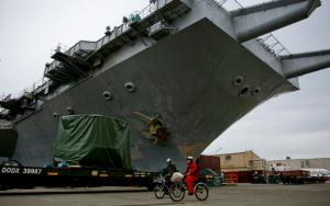 Following a decommissioning ceremony, two shipyard workers ride their bicycles by the the USS Enterprise aircraft carrier at Newport News Shipbuilding in Newport News, Va., on Friday, Feb. 3, 2017. It served more than 50 years, playing a role in the Cuban Missile Crisis, Vietnam and the wars in Iraq and Afghanistan. (Kristen Zeis/The Virginian-Pilot via AP)