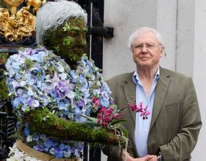 FILE - In this Thursday, May 17, 2012 file photo, British television personality Sir David Attenborough stands with a floral sculpture of himself at Kew Gardens in London. From jungles to deserts to mountains, the BBC's epic nature series "Planet Earth II" takes viewers around the world - and around many genres of television. The seven-part series, which begins in the U.S. on Saturday, Feb. 18, 2017 with a simulcast on BBC America, AMC and SundanceTV, is a spectacular demonstration of how far nature programs have come. And no one has been more closely linked to their evolution than David Attenborough, the 90-year-old naturalist who narrates "Planet Earth II." (AP Photo/Kirsty Wigglesworth, File)