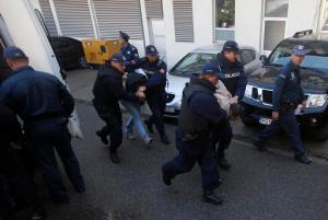 In this Sunday, Oct. 16, 2016 file photo, Montenegrin police officers escort people suspected of planning armed attacks after the parliamentary vote in Podgorica, Montenegro. Montenegro's special prosecutor Milivoje Katnic, has accused Russia and its secret service operatives of plotting a coup attempt that included plans to kill the small Balkan country's former prime minister, Milo Djukanovic, following an investigation. (AP Photo/Darko Vojinovic, File)
